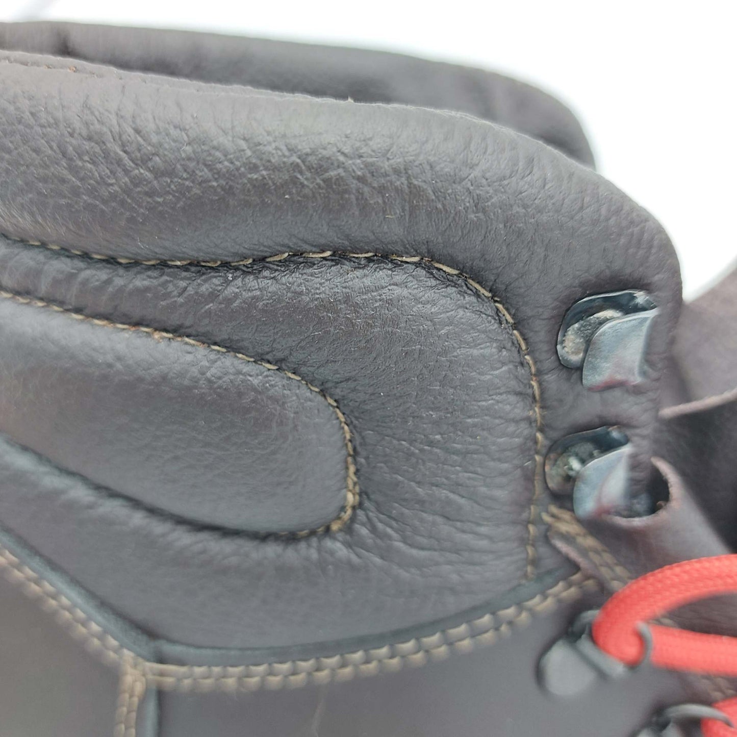 Dettaglio scarpone artigianale in cuoio testa di moro con cuciture resistenti e occhielli metallici