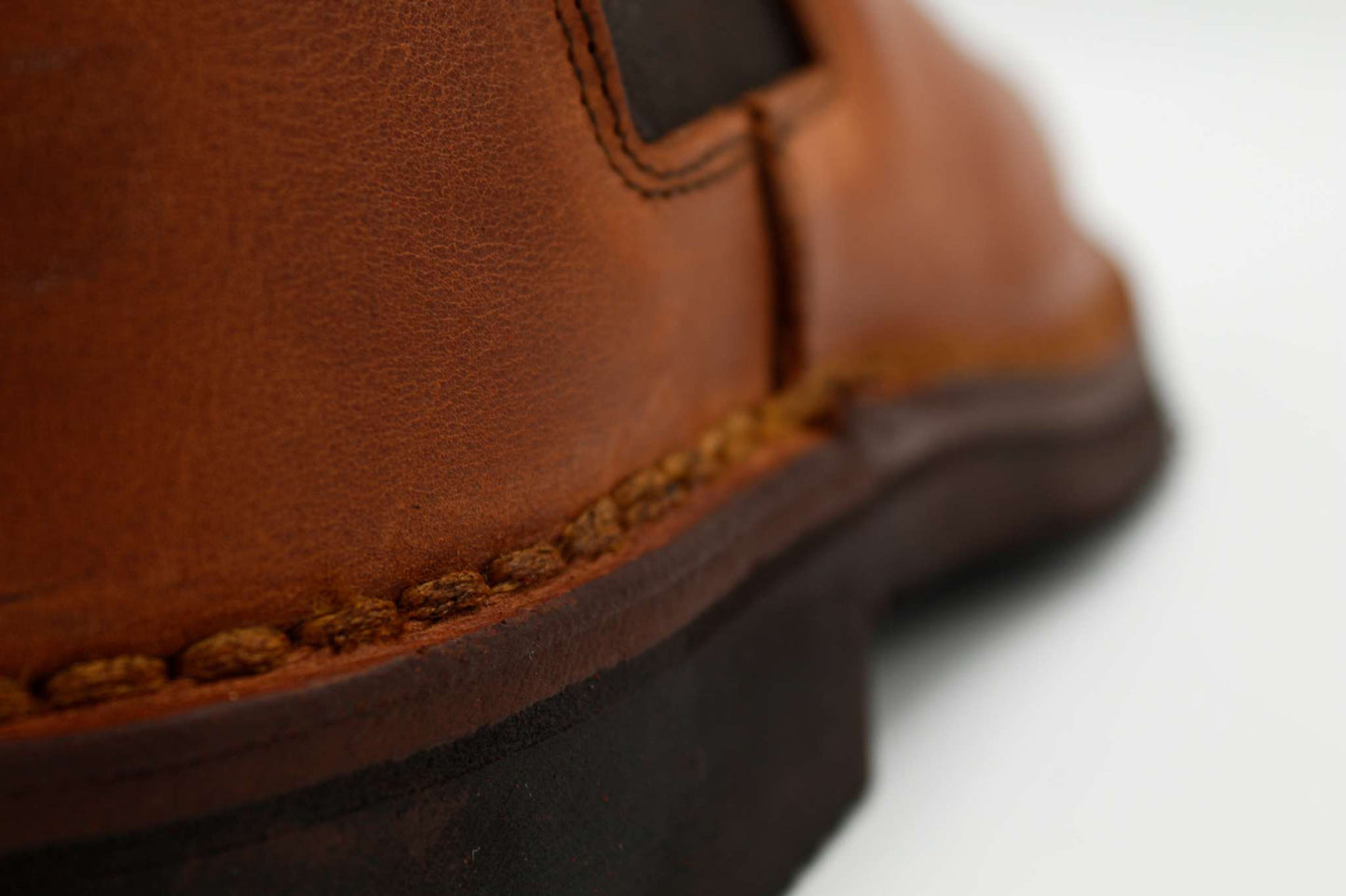 close-up of brown leather stivaletto with detailed stitching and rubber sole
